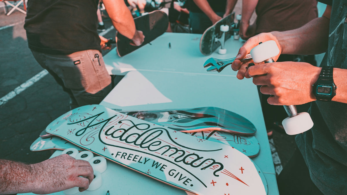 a group of people standing around a table with a skateboard