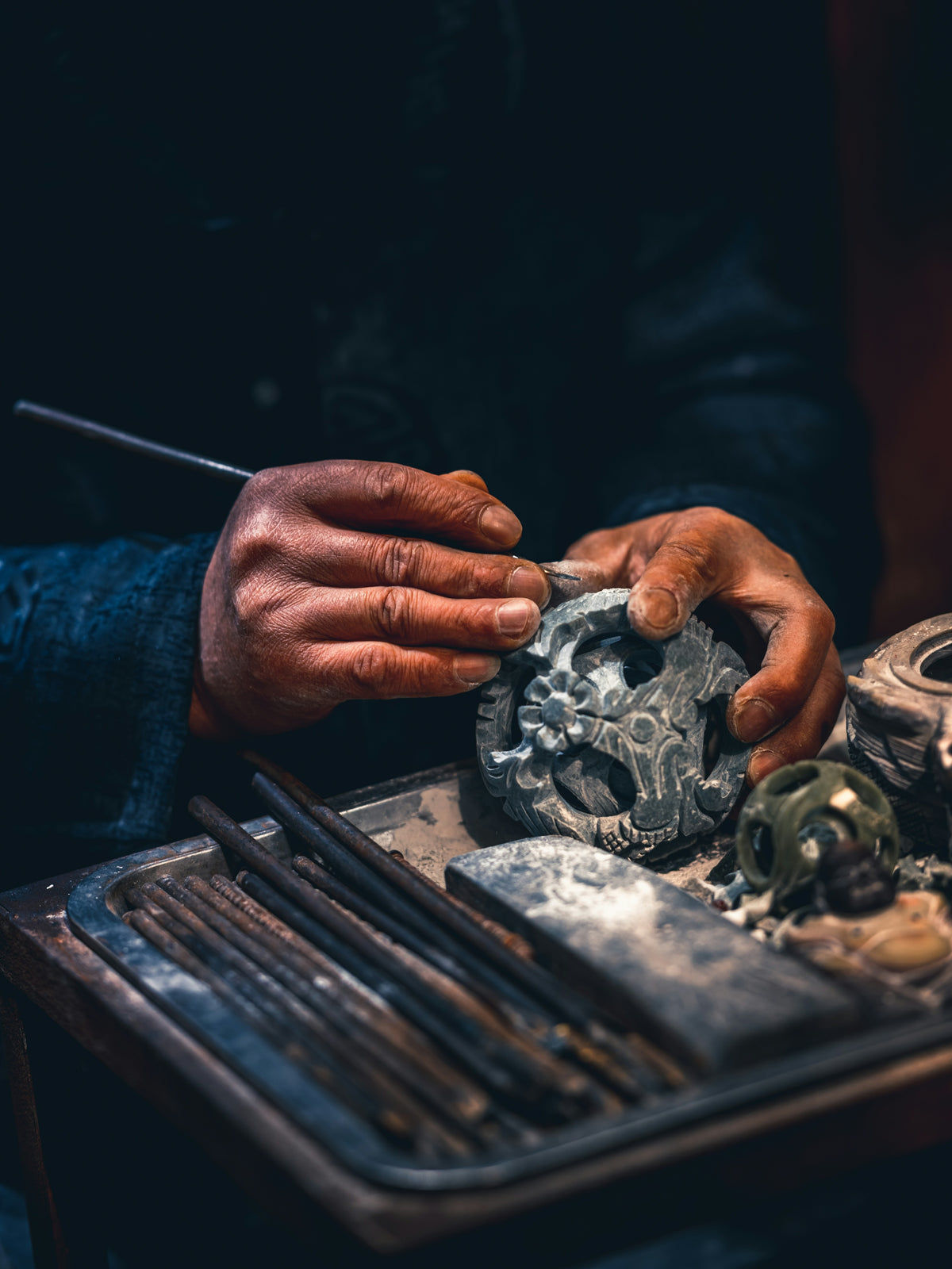 Artisan carves intricate details into stone sculpture